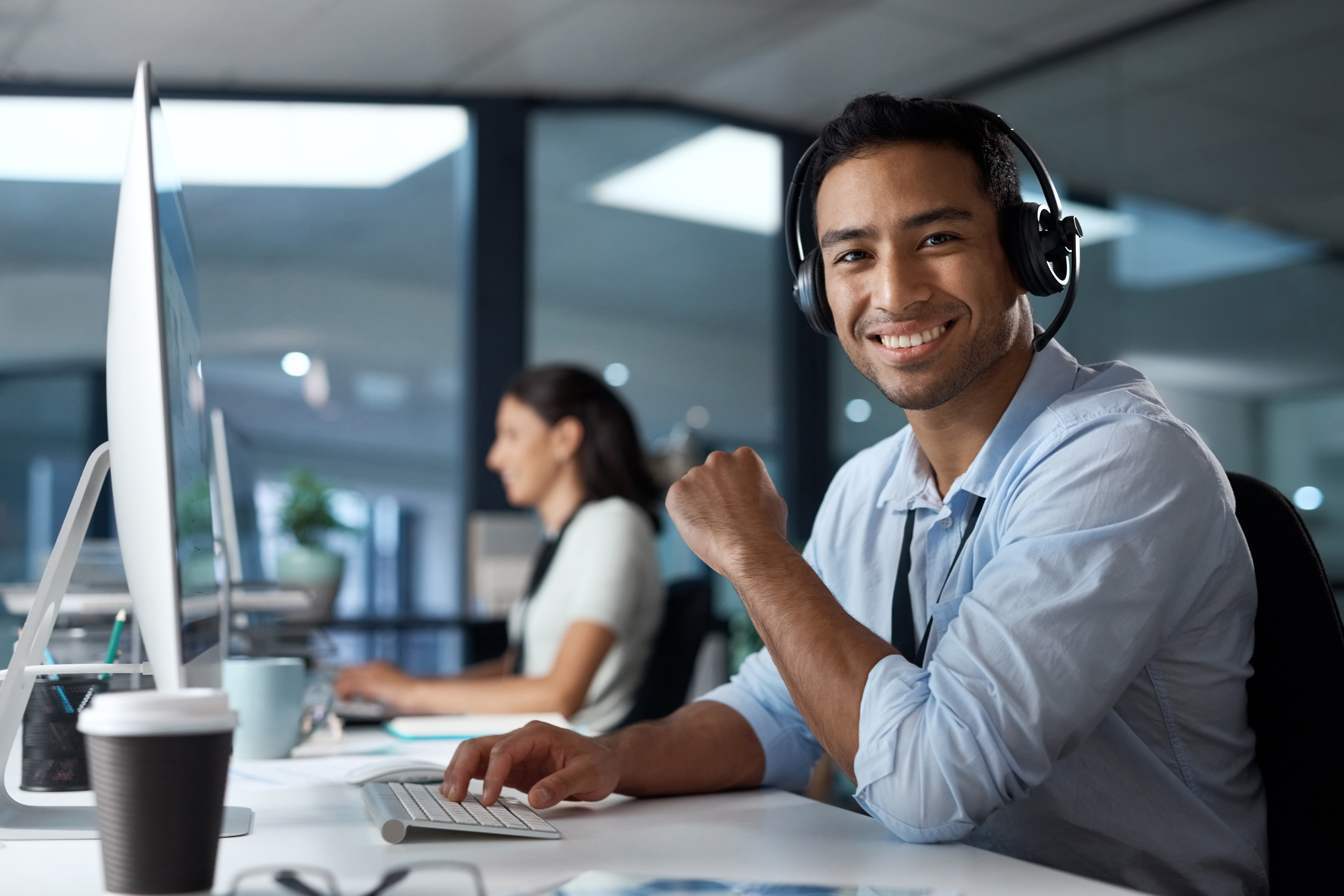 Man-using-headset-and-computer-in-a-modern-office