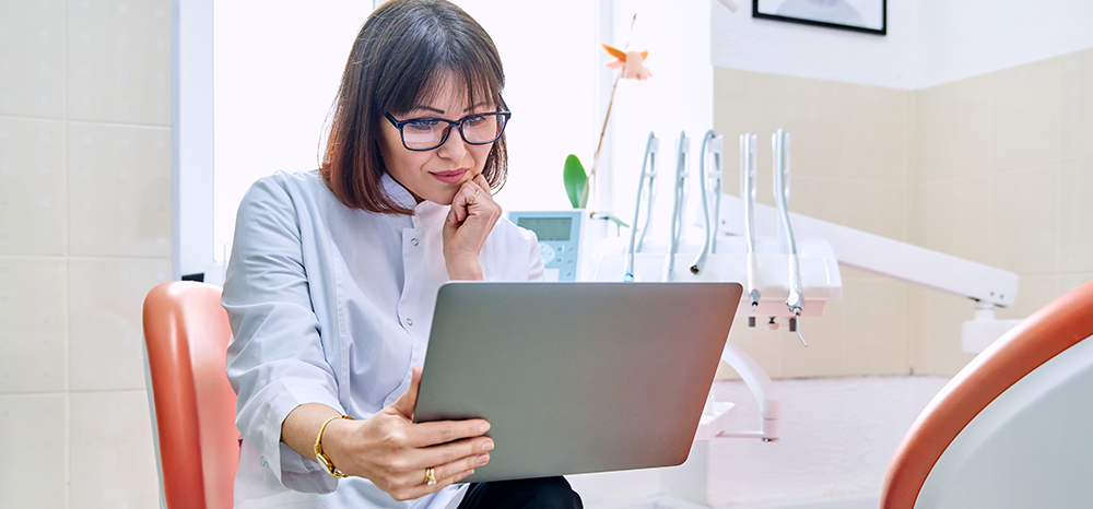 woman-dentist-looking-at-computer-sm_503355815